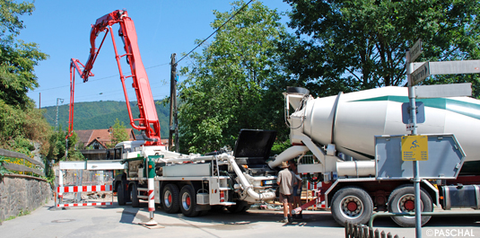 Concrete transported on-site by large mixer trucks